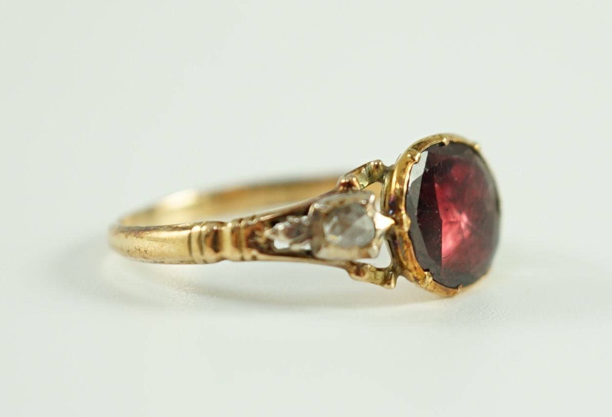 A George III gold, foil backed garnet and rose cut diamond set three stone ring